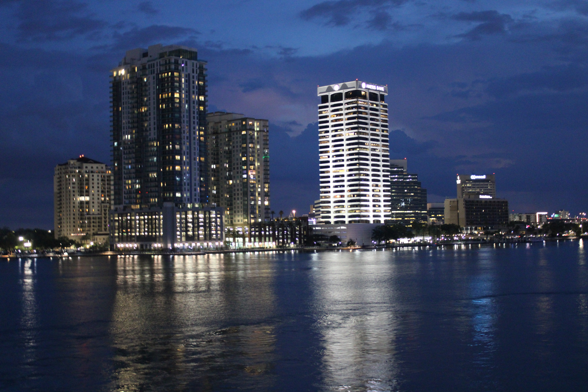 Jacksonville Southbank skyline at night with the Ameris Bank tower and high-rise condos reflected on the St. Johns River