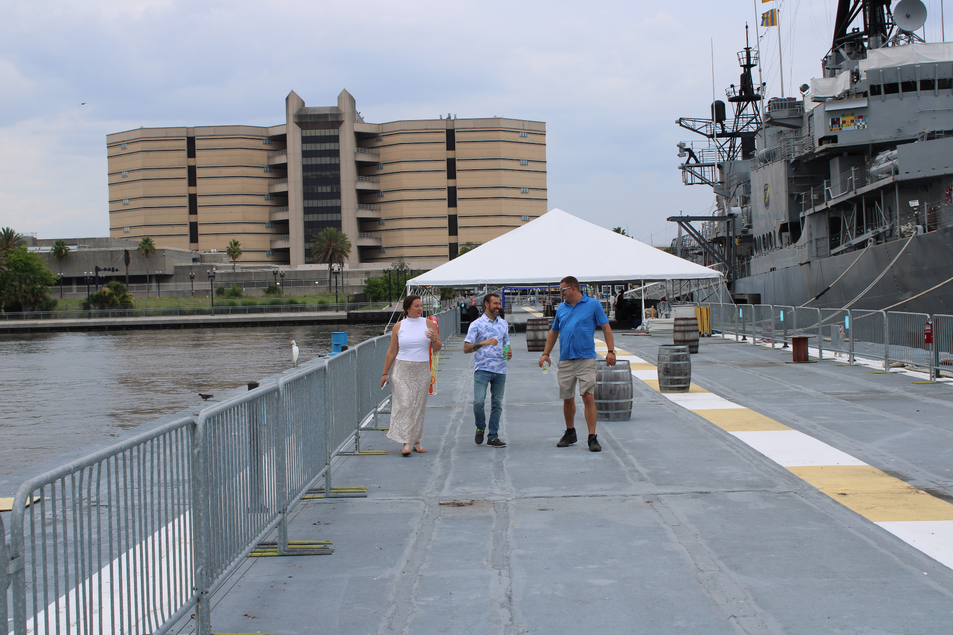 Three guests walking along the pier beside the USS Orleck during the Life Well Balanced dinner