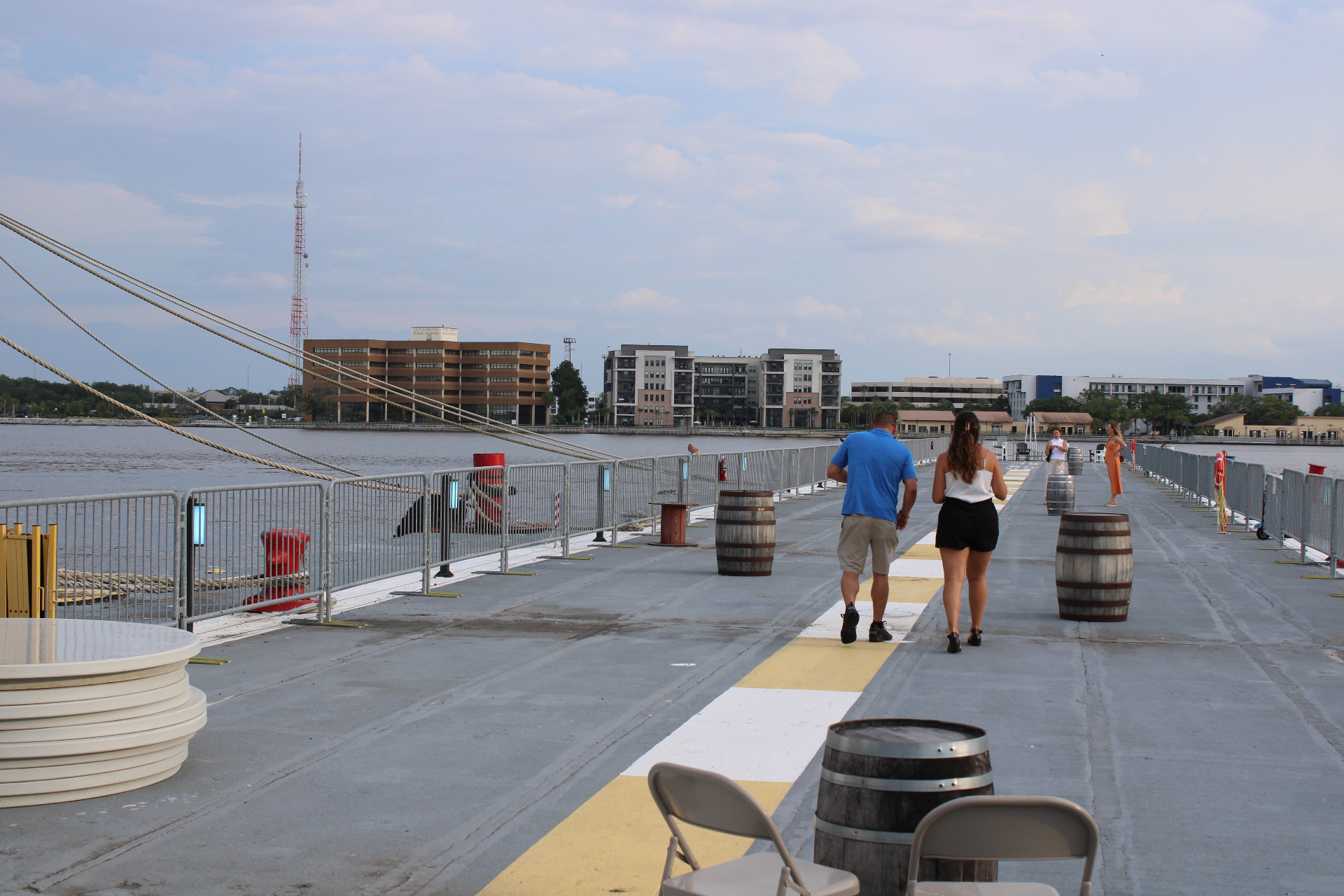 Guests walking along the pier deck of the USS Orleck with the Jacksonville riverfront in the background