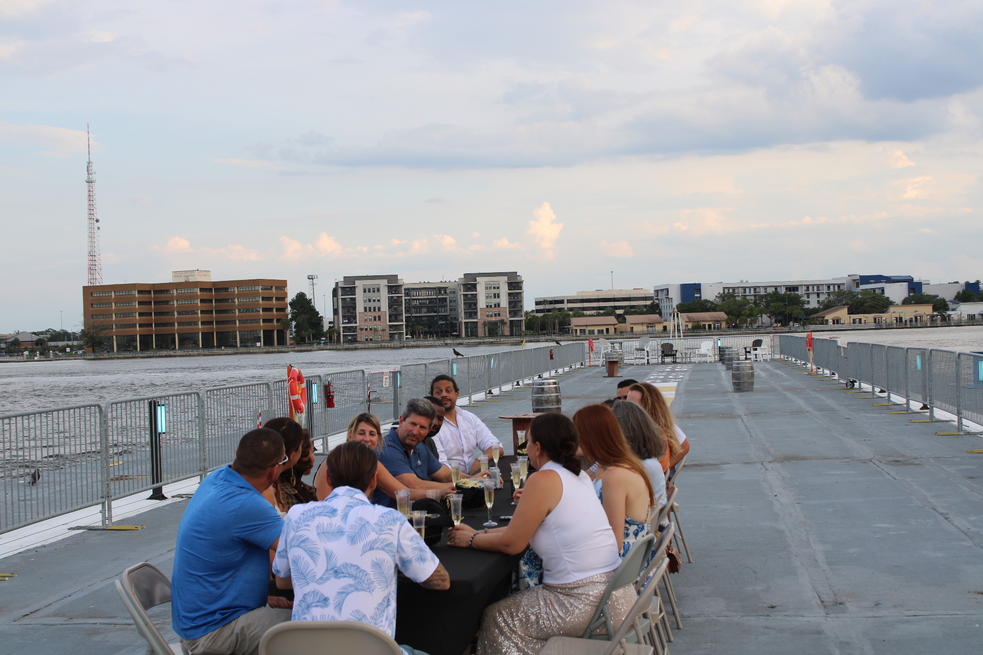 Dinner guests gathered along the pier with the St. Johns River and Jacksonville riverfront in the background